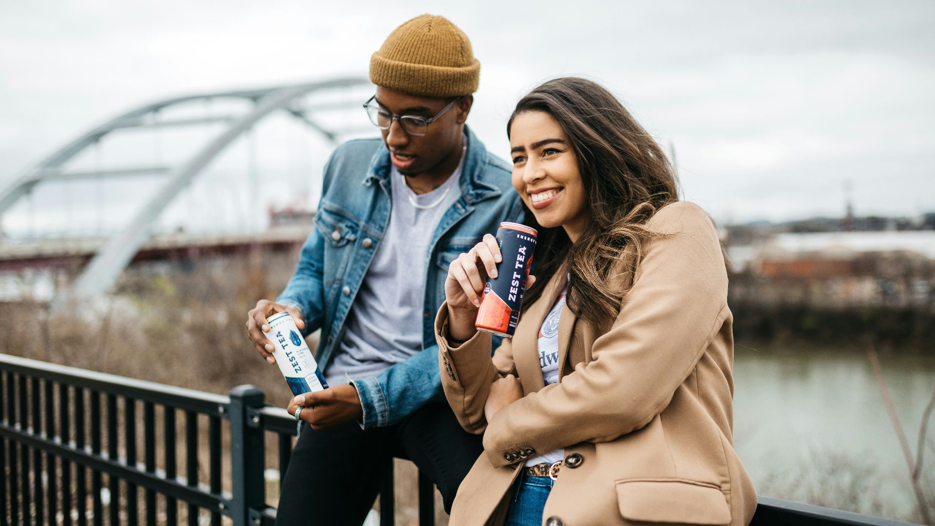 woman in brown coat holding white and blue labeled bottle