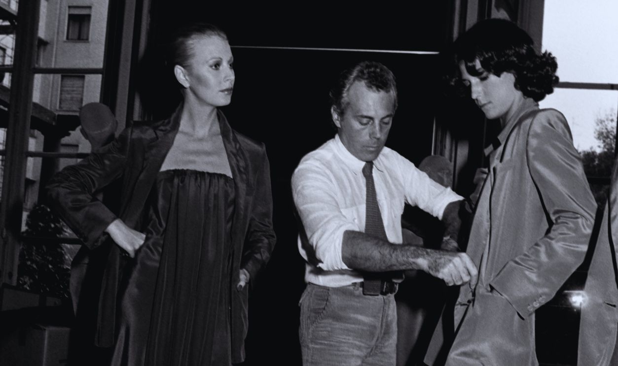 Gettyimages - 1467633598, Giorgio Armani, Milan - 10 Oct 1977 Designer Giorgio Armani Adjusts Models for Giorgio Armani Spring 1978 Ready to Wear Advance 
