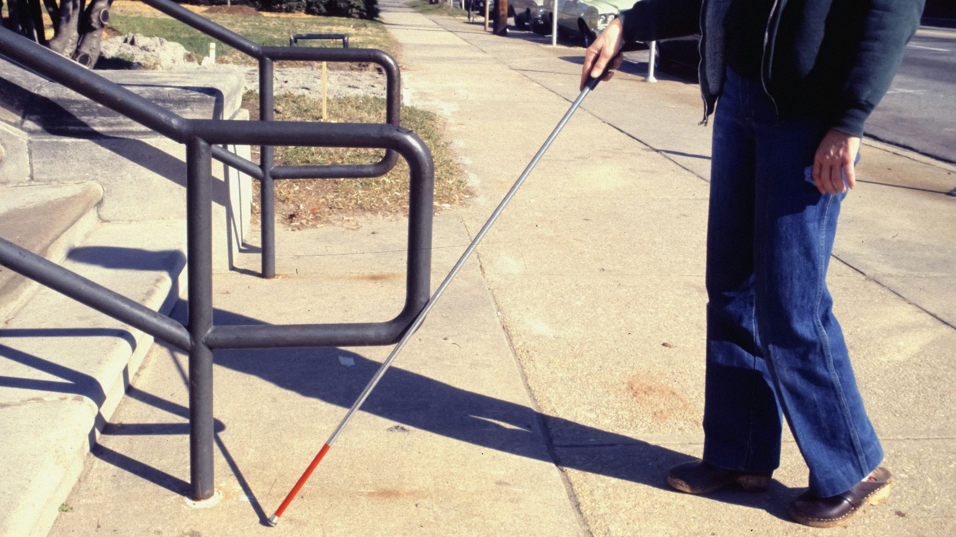 a man walking a dog on a leash down a sidewalk