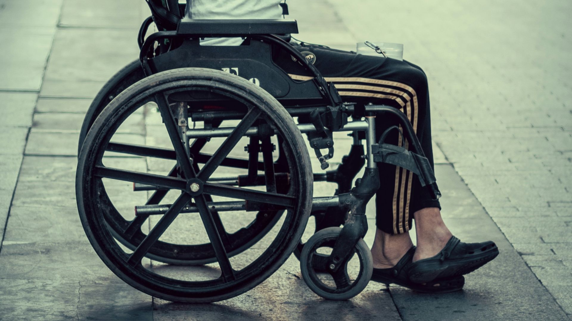 a man in a wheelchair sitting on a sidewalk