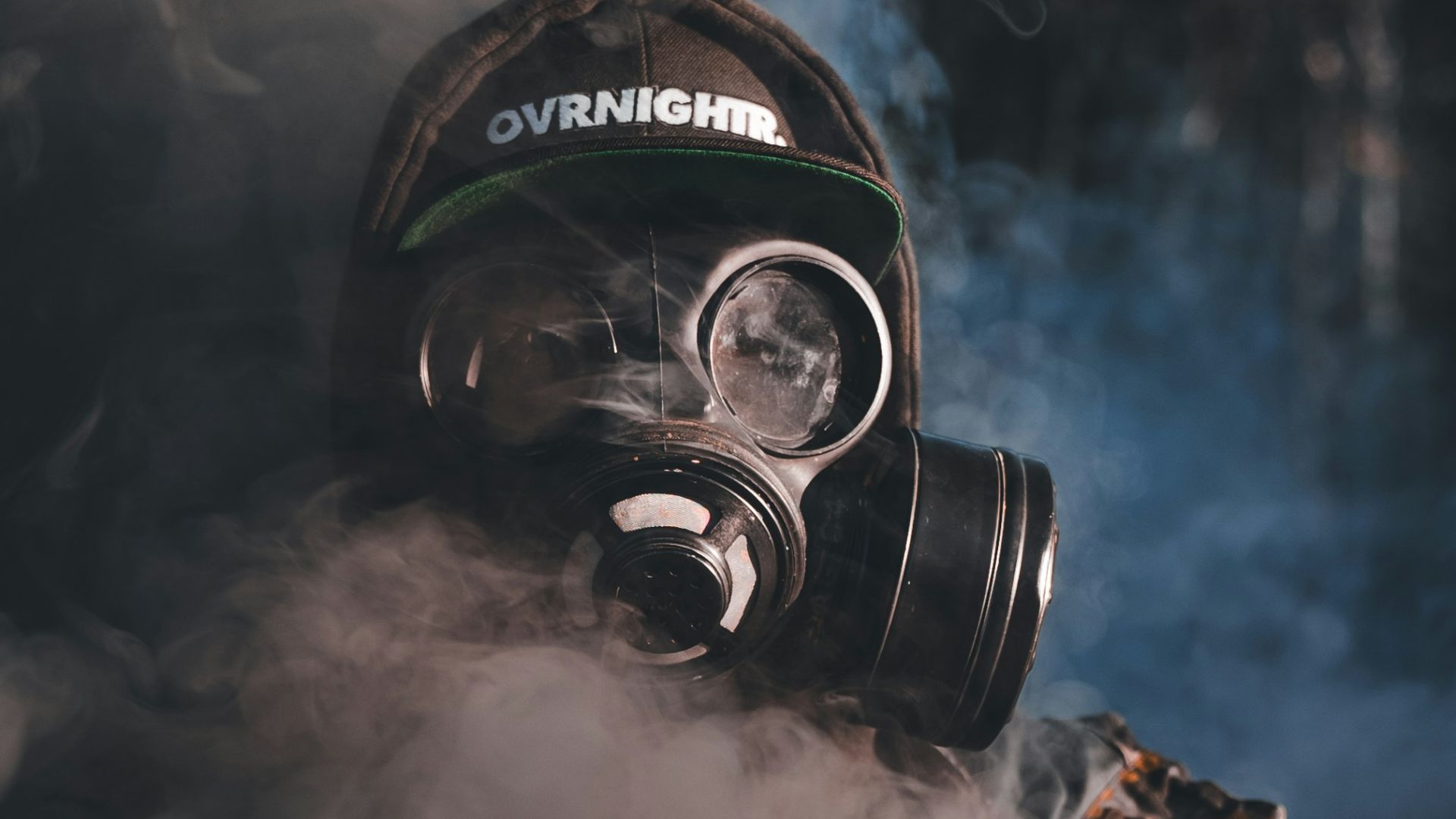 A person wearing a gas mask and smoking a cigarette