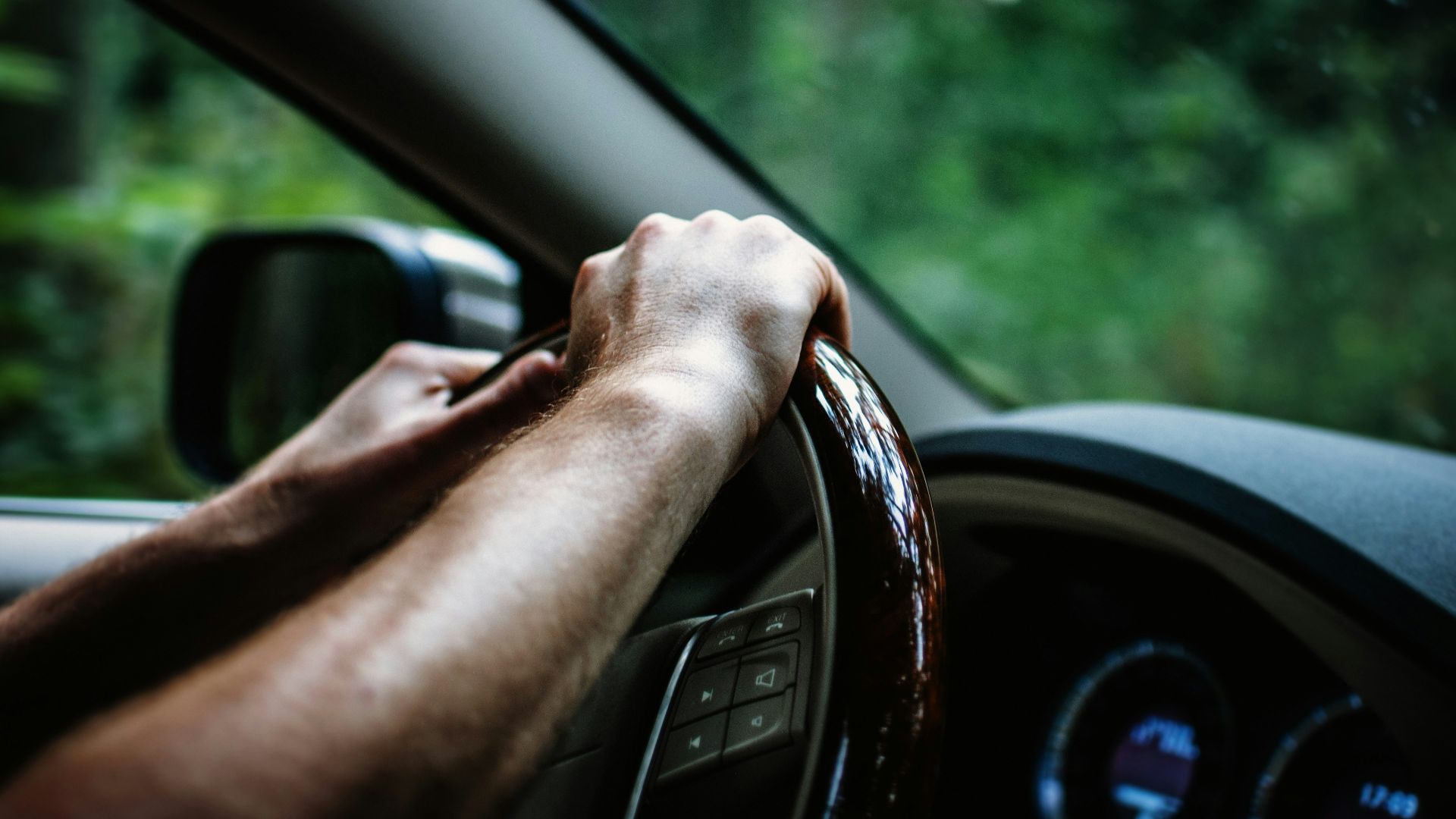person holding car steering wheel