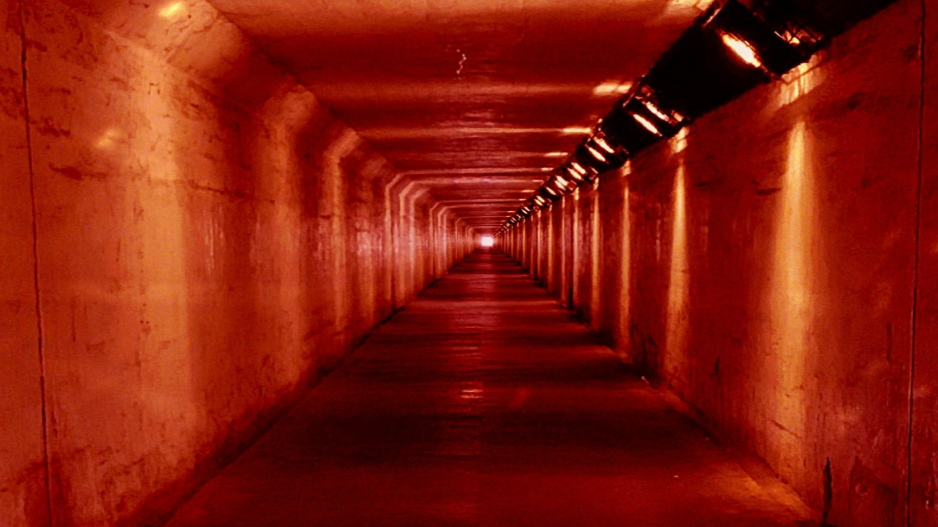 concrete tunnel with red lights