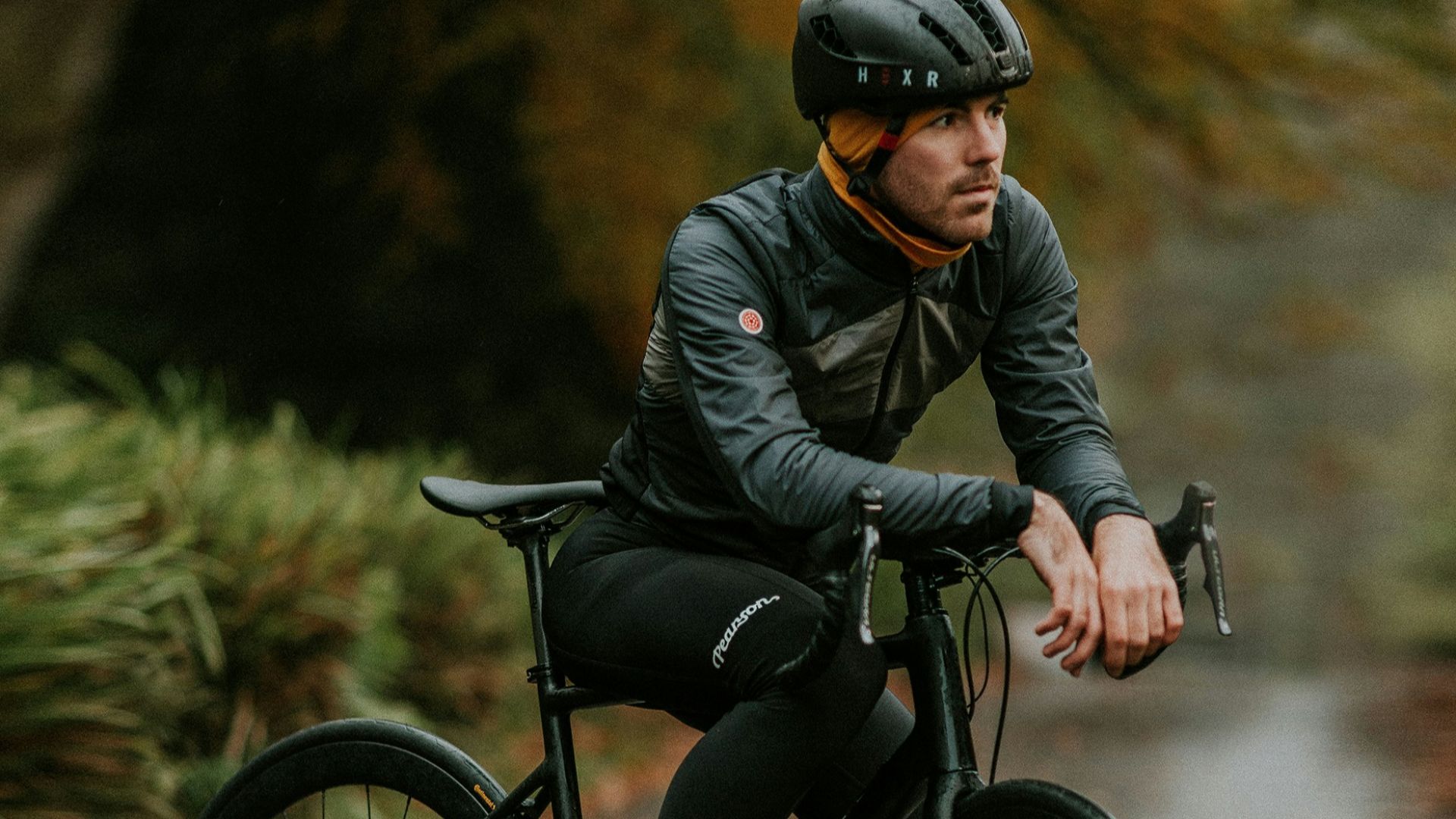 man sitting on road bike near trees