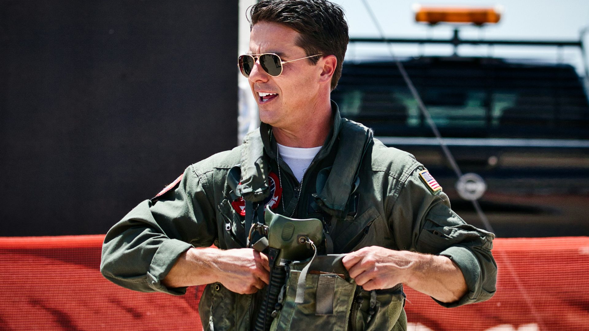 A smiling pilot puts on his flight gear.