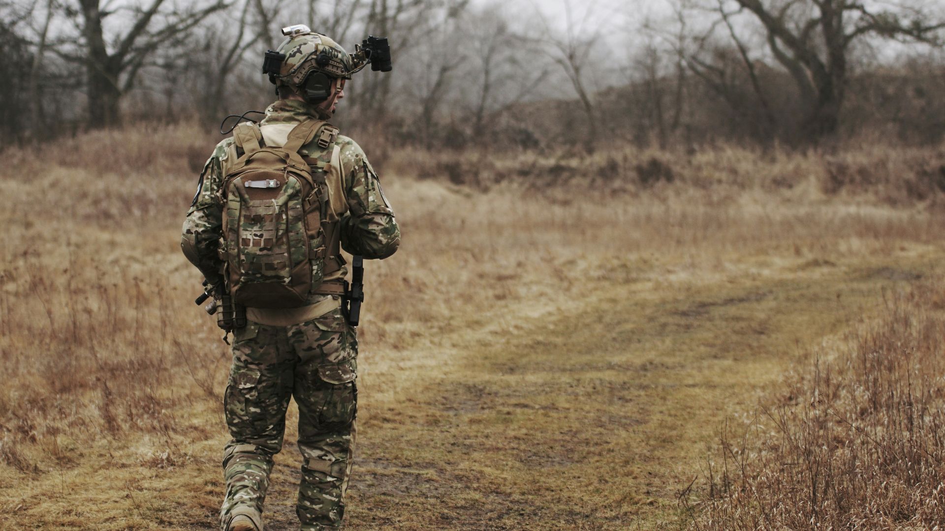 man walking on brown grass field