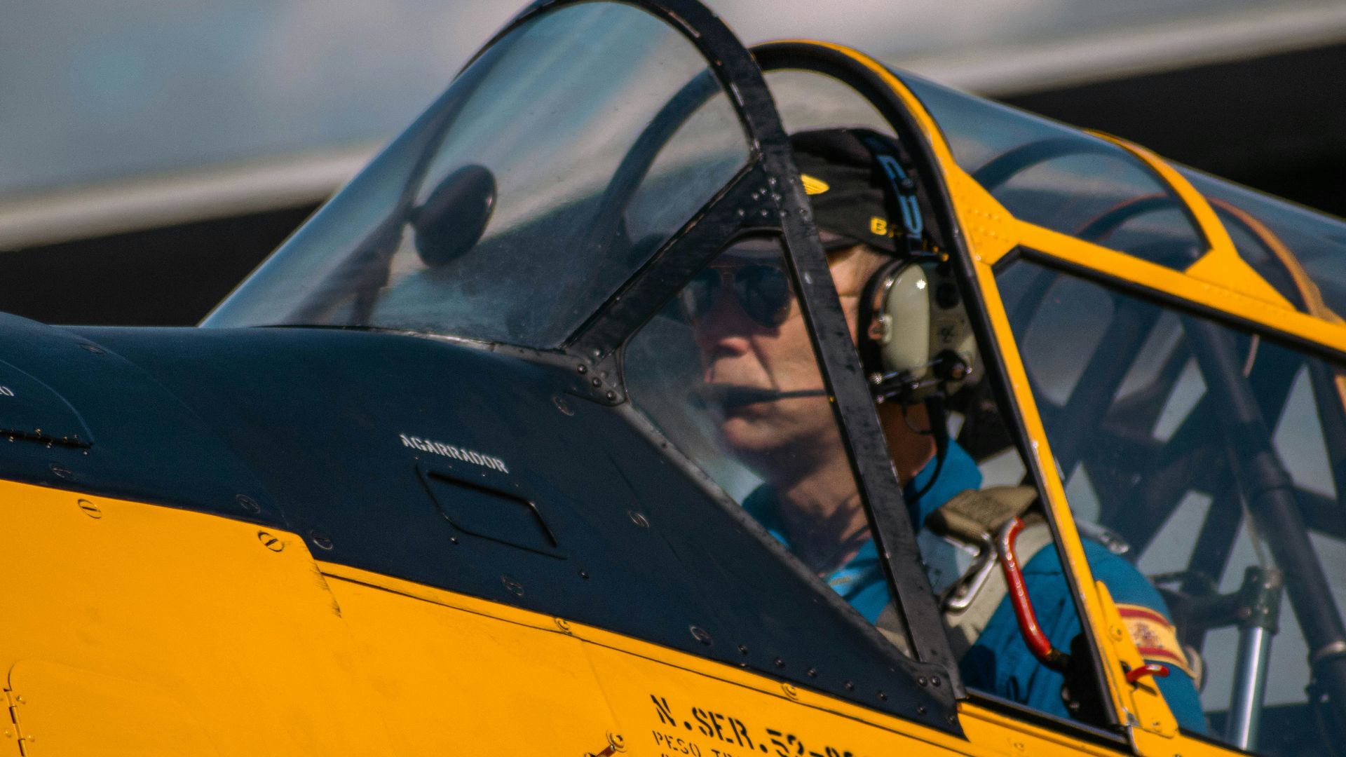 a man sitting inside of a yellow fighter jet