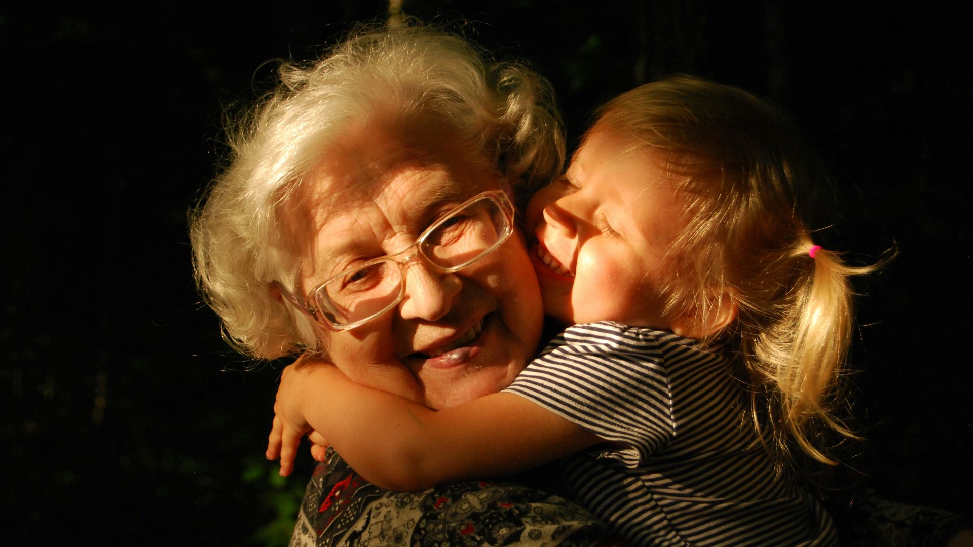 woman in black and white striped shirt hugging girl in black and white striped shirt