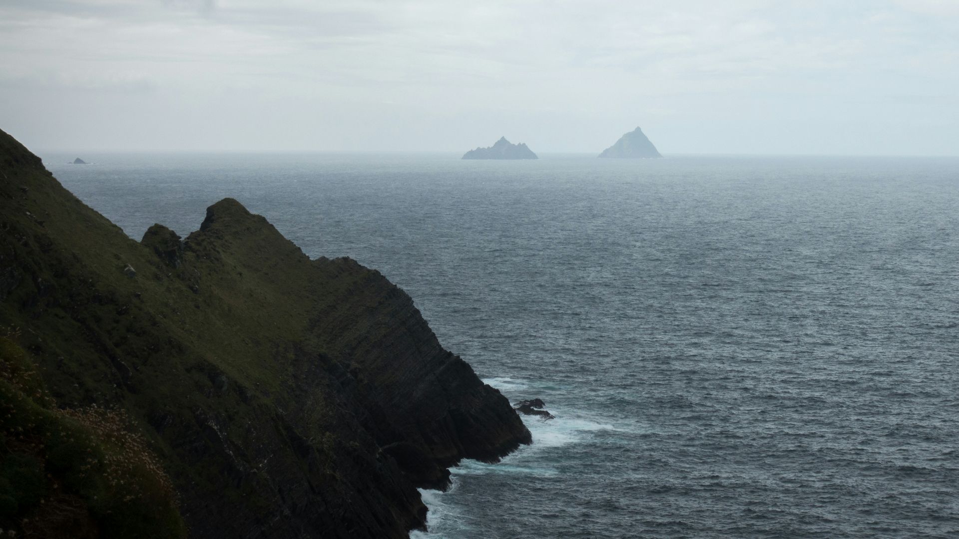 body of water and mountain with fog
