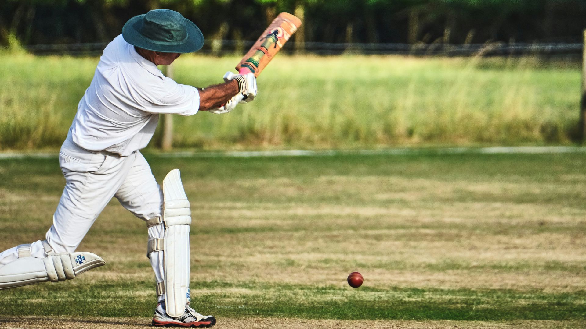 man in white pants and blue baseball mitt holding baseball bat during daytime