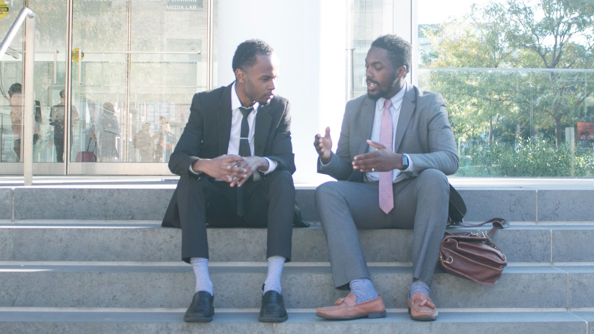 a couple of men sitting on top of a set of stairs