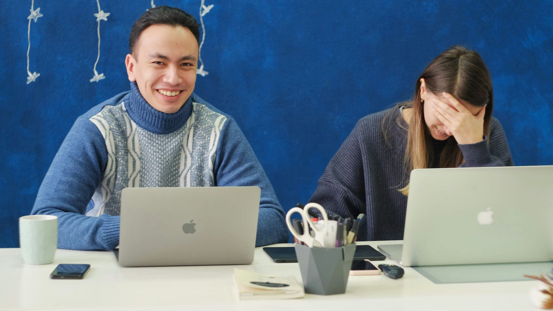 woman in gray sweater using silver macbook