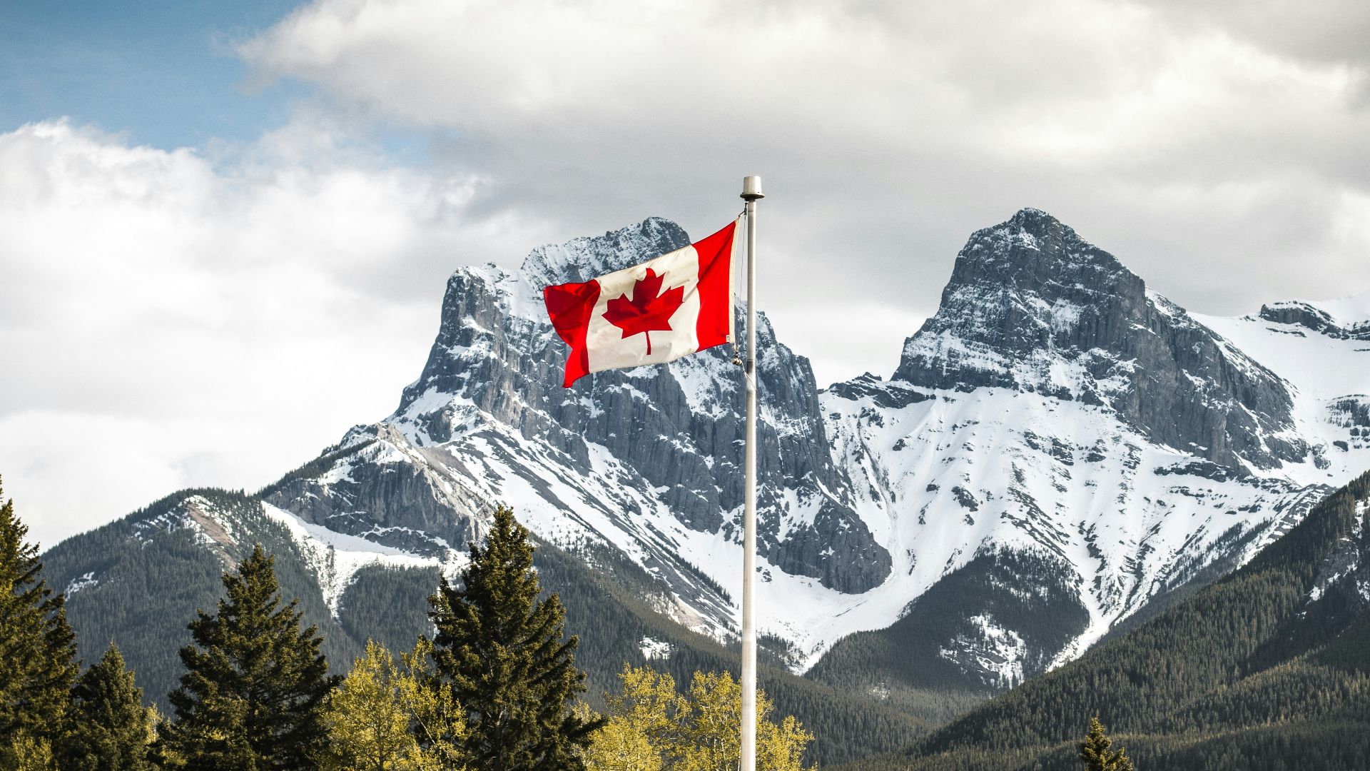 us a flag on pole near snow covered mountain