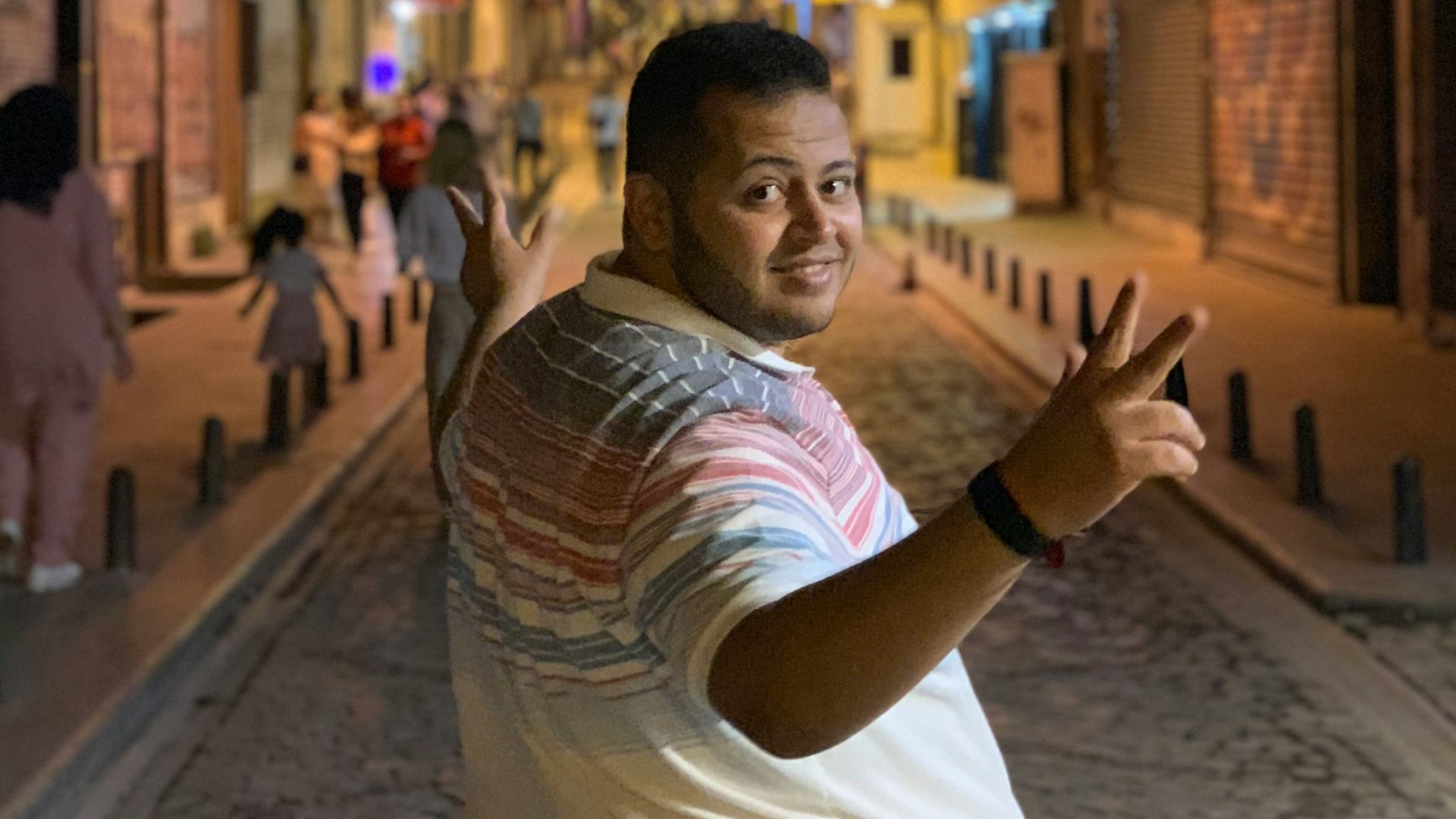 man walking in road between buildings