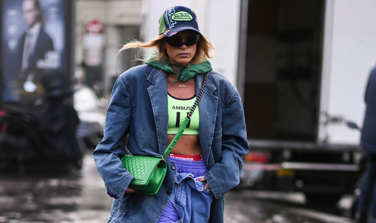 PARIS, FRANCE - SEPTEMBER 27: A guest is seen wearing a jean jacket, Ambush top, jean pants, Von Dutch hat and green Chanel bag outside the Koche show during Paris Fashion Week S/S 2023 on September 27, 2022 in Paris, France. 