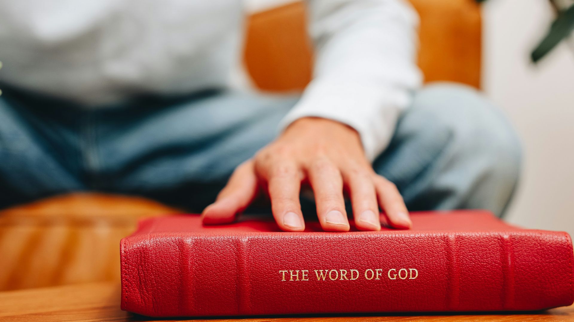 A man sitting at a table with a red book
