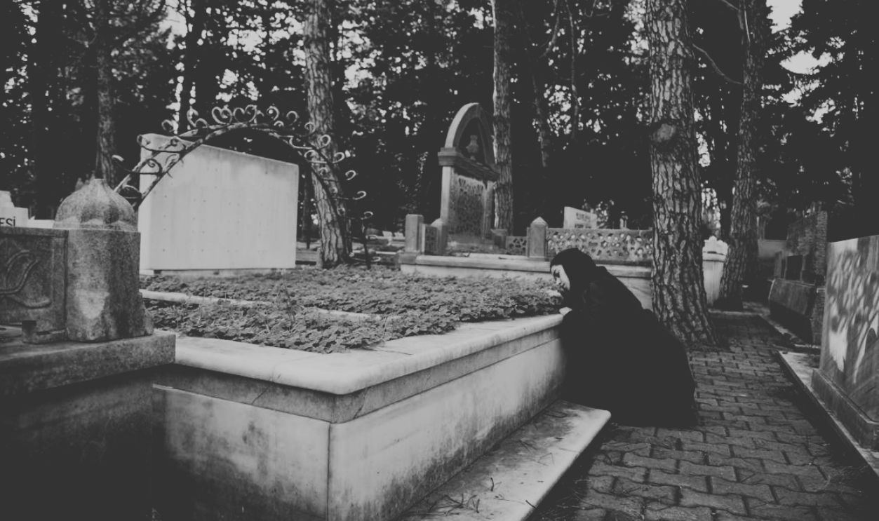 Woman leaning on grave