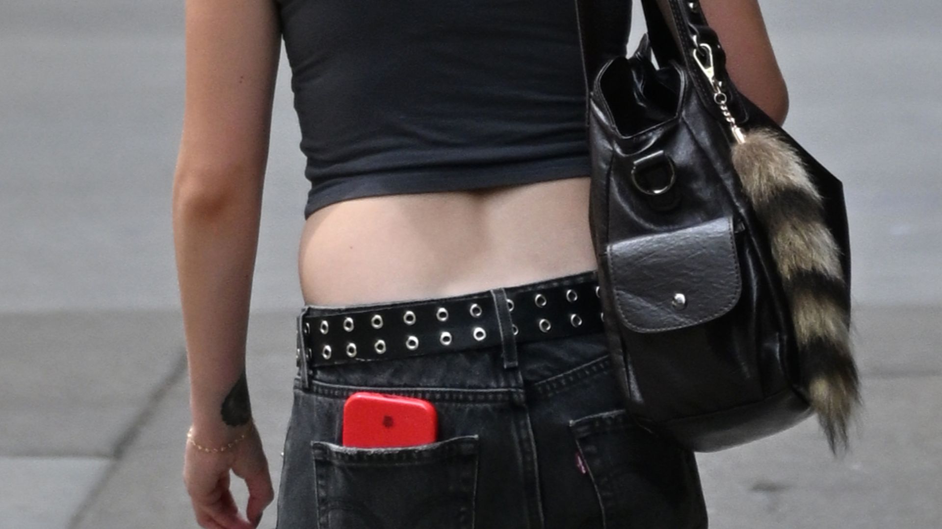 File:Young woman in crop top and low-rise jeans, with bags, Lake Street, Chicago, 2025.jpg