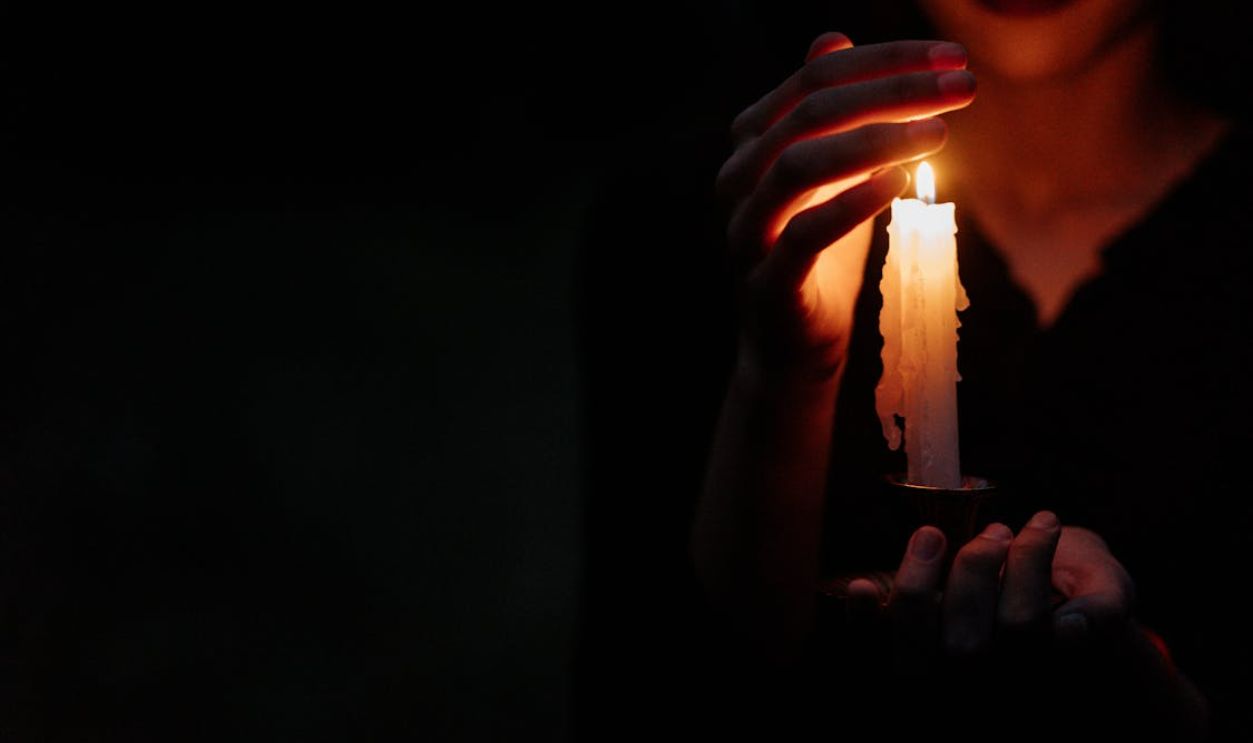 Person covering a candle