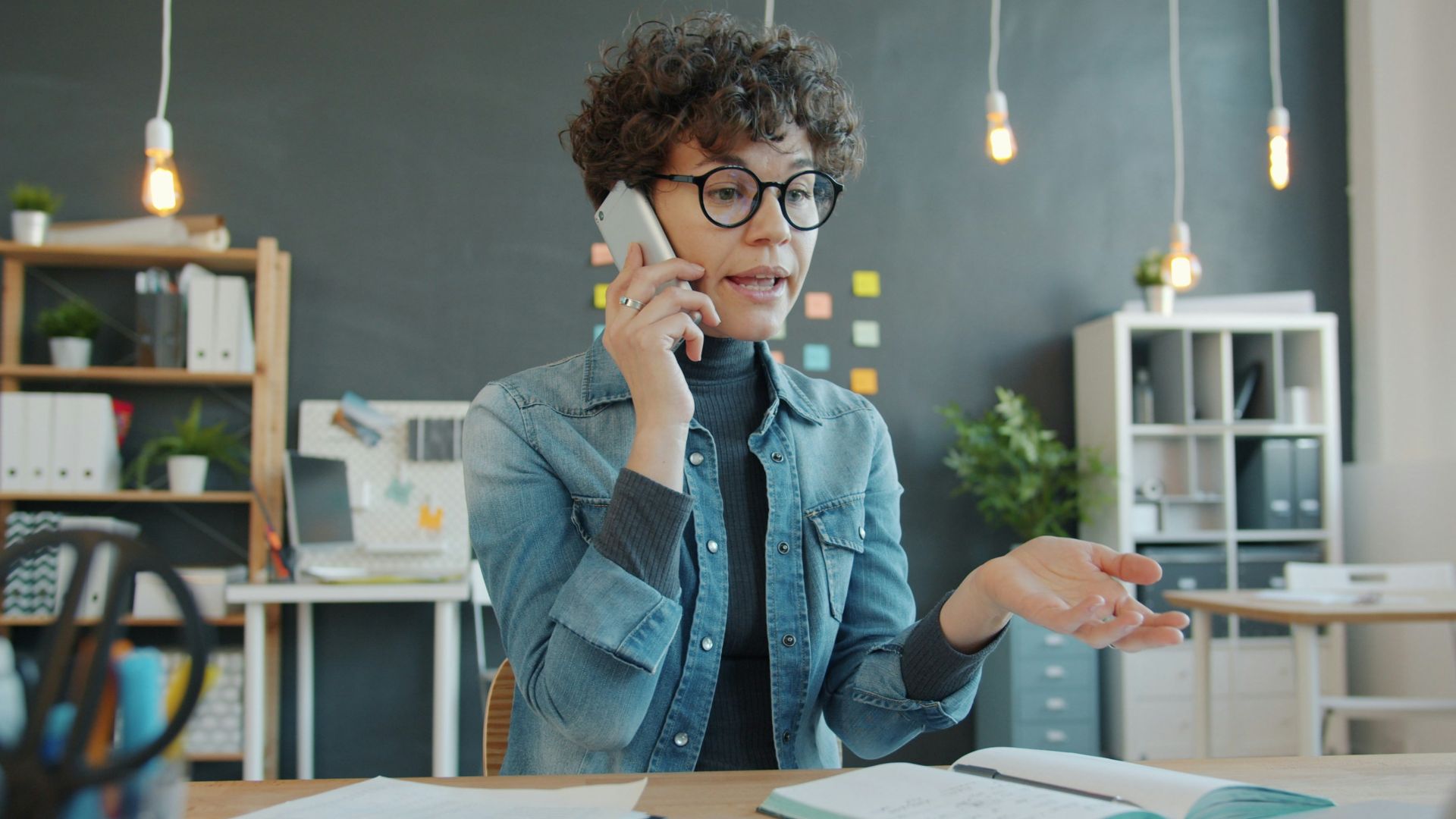 Woman talking on phone at desk in office