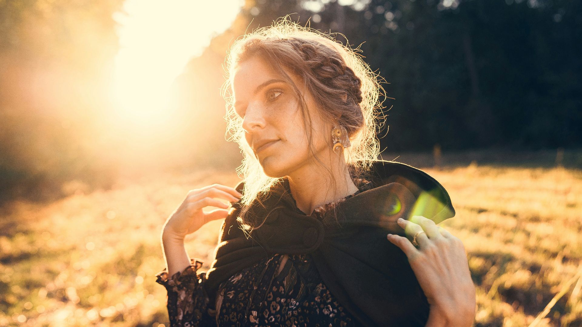 a woman standing in a field holding a piece of fruit
