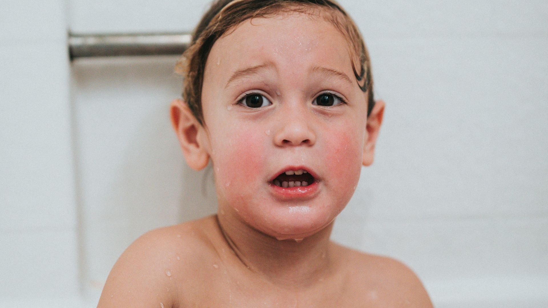 topless boy holding white and blue ball