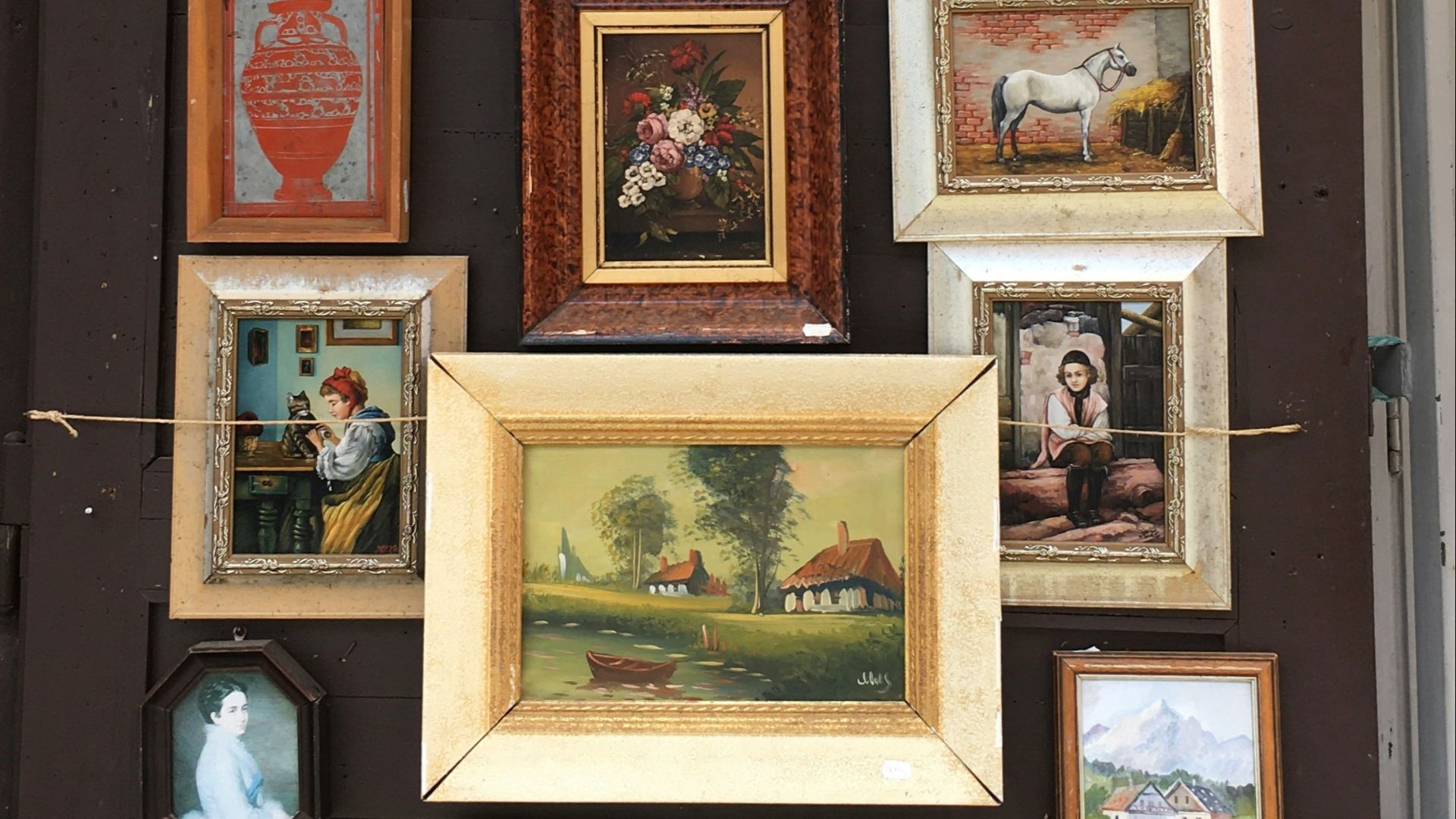 a wall with many framed pictures on it