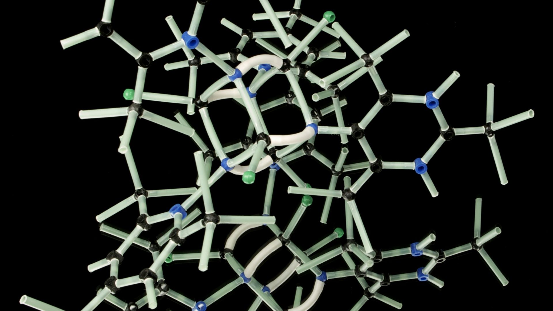 white plastic wire puzzle with black background