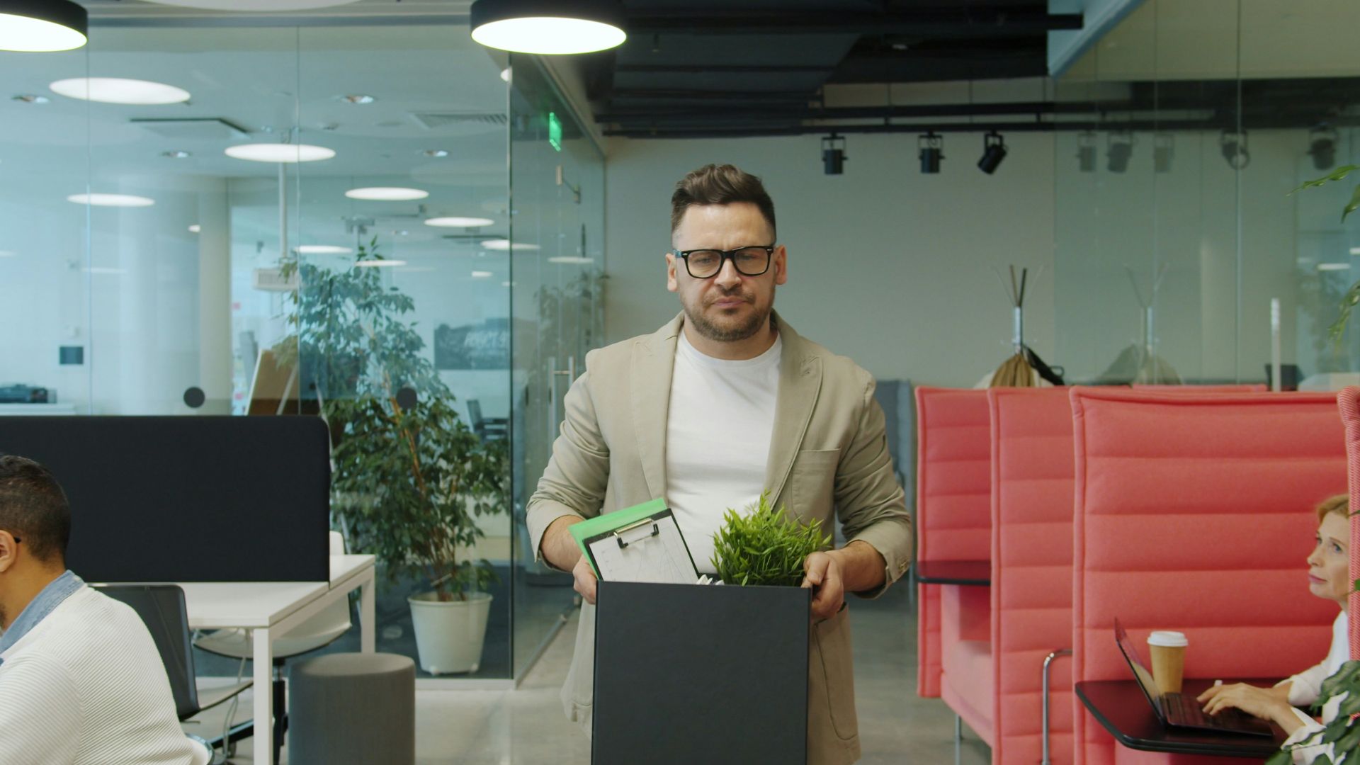 Man carrying box of belongings in office