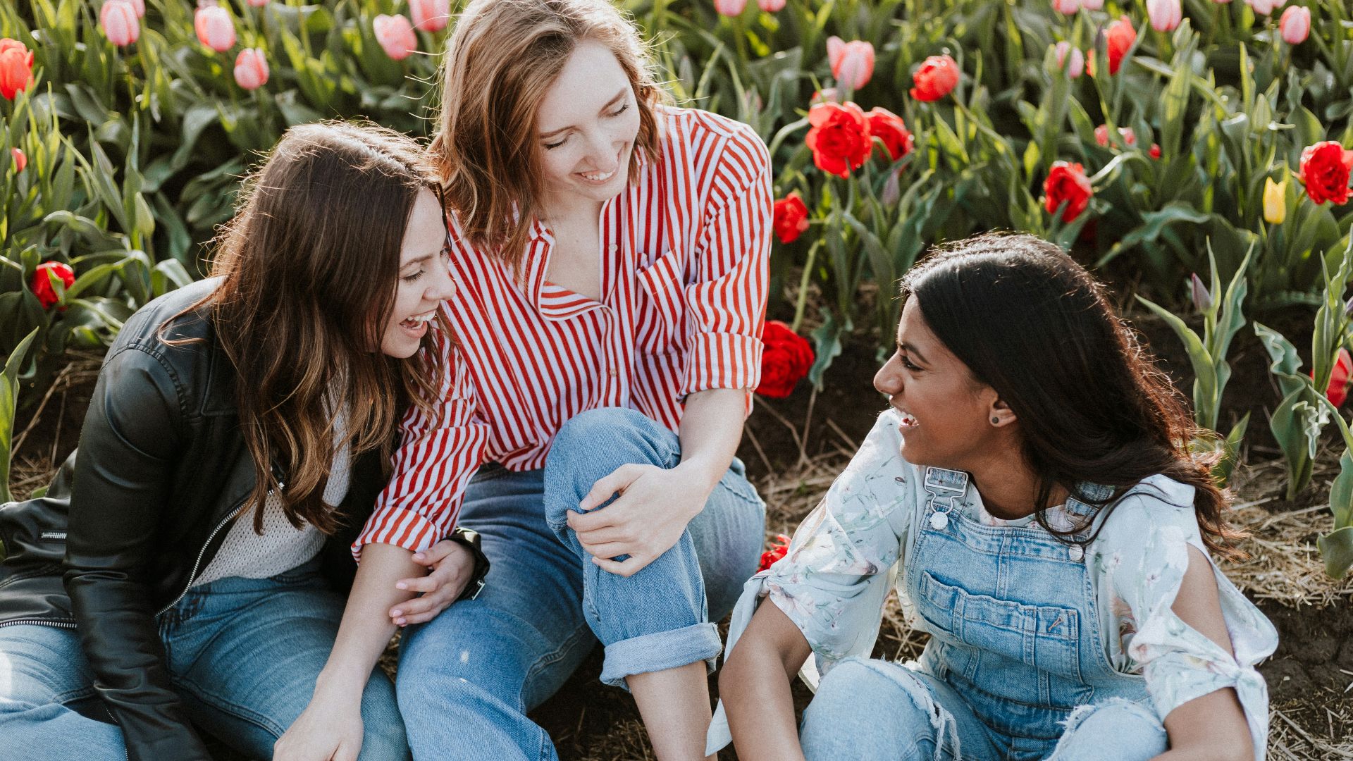 three woman sitting near the flower
