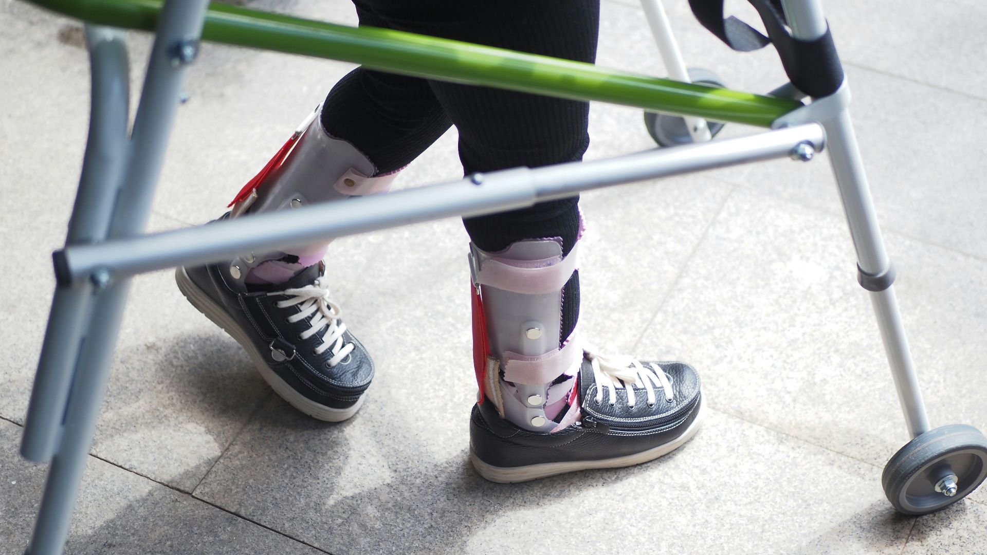 A person standing next to a green walker