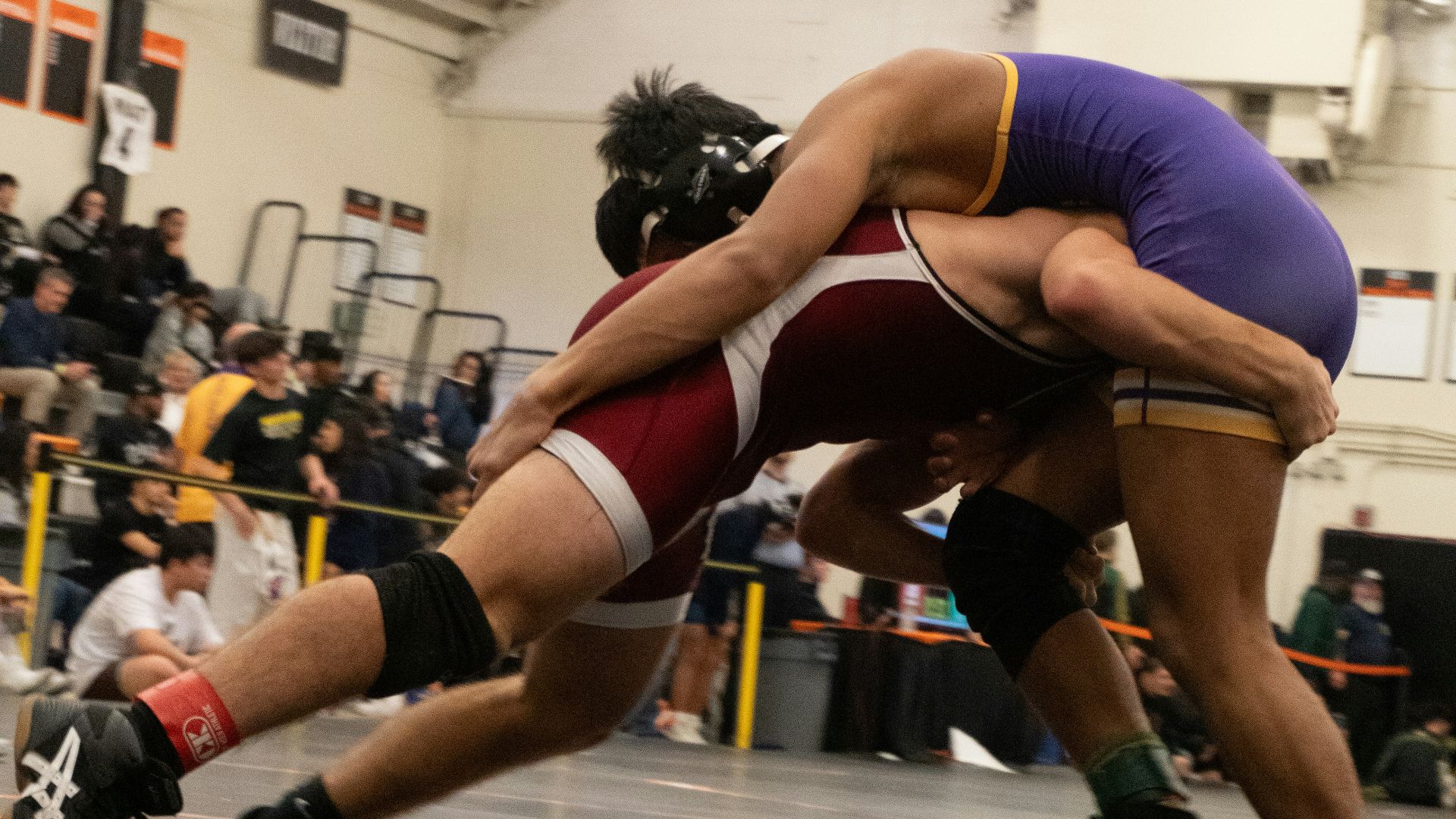 Two wrestlers in a wrestling match with a crowd watching