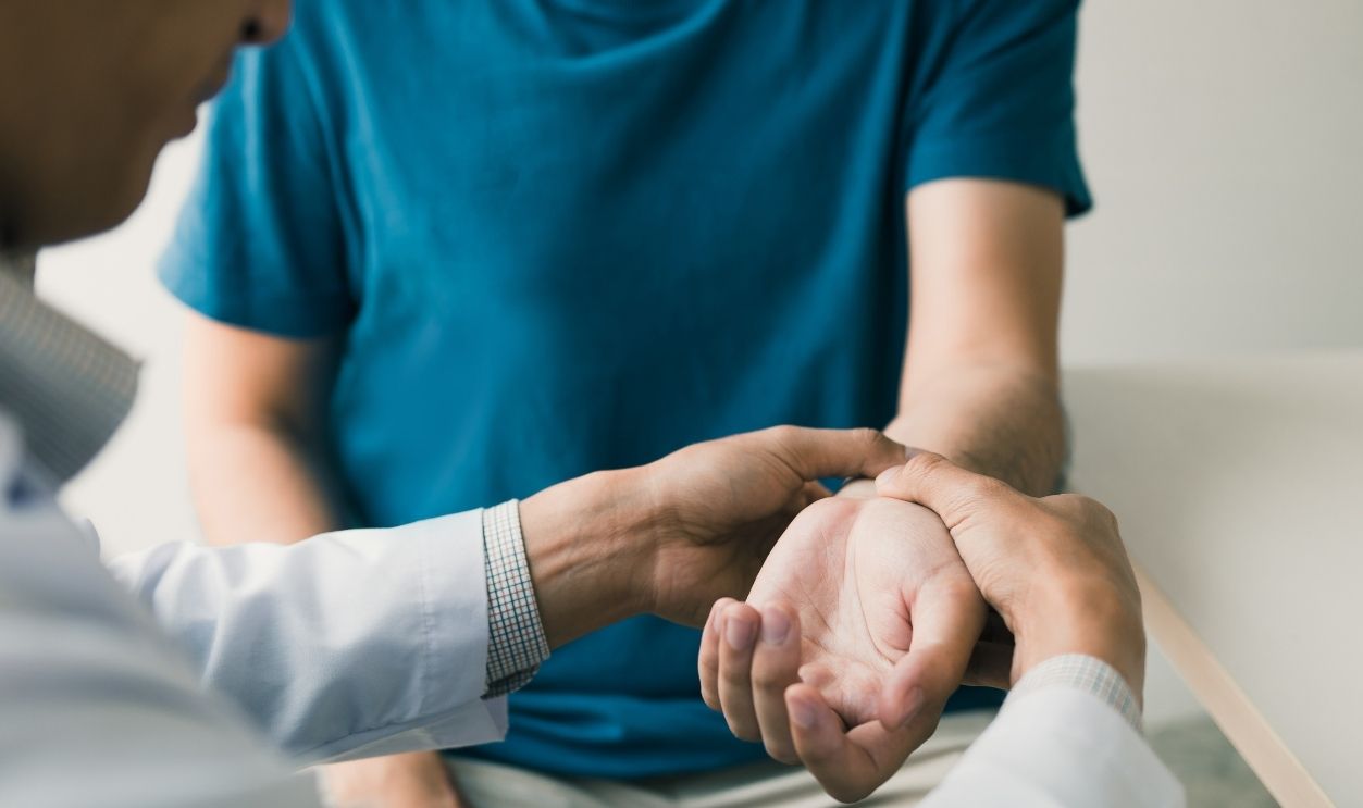 Physical therapist checks the patient wrist by pressing the wrist bone in clinic room.