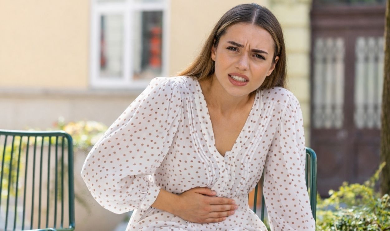 2573175631- Caucasian young woman traveler feeling sudden strong abdominal stomach ache- Andrii Iemelianenko