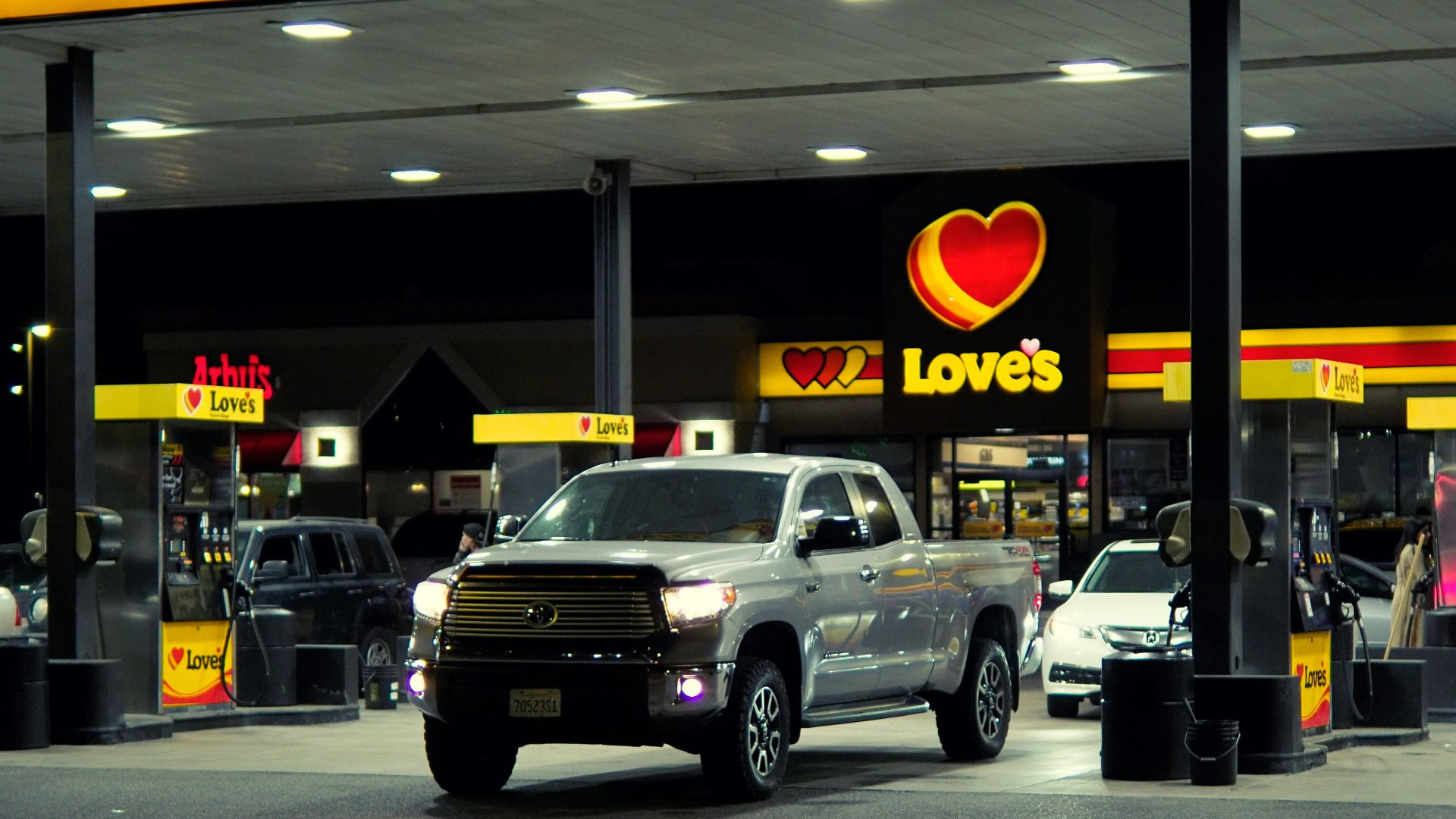 a couple of trucks are parked in front of a love's gas station