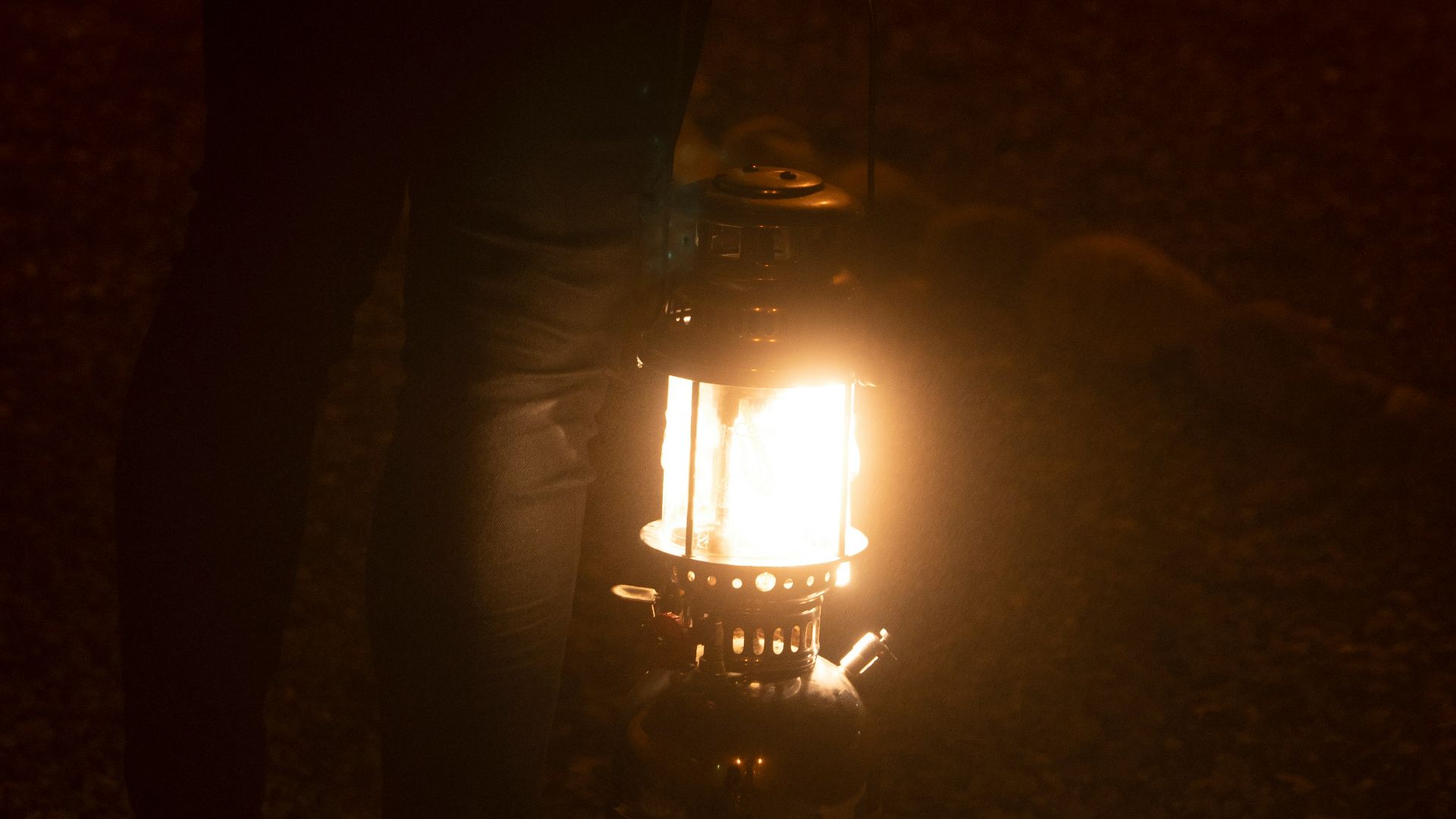 a person holding a lantern in the dark