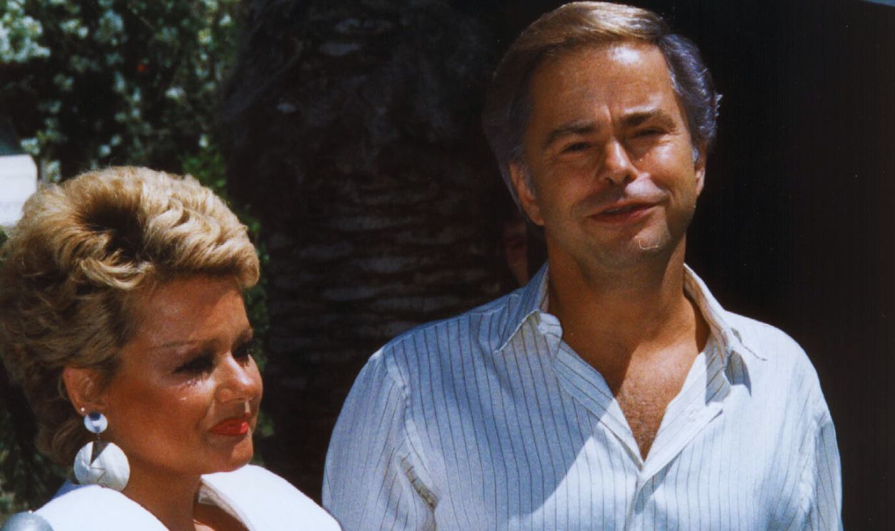 Gettyimages - 51965541, Reverend Jim Bakker and his wife Tammy Faye Bakker PALM SPRINGS, CA - MAY 1: Reverend Jim Bakker and his wife Tammy Faye Bakker are shown at their first press conference 01 May 1987, Palm Springs, CA, since Bakker was forced out of PTL church. 