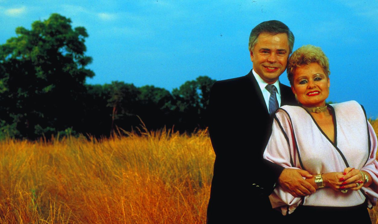 Gettyimages - 50581161, James Bakker [& Wife] Former televangelists Jim and Tammy Faye Bakker, in expensively tailored clothes, standing in the middle of a wheat field. 