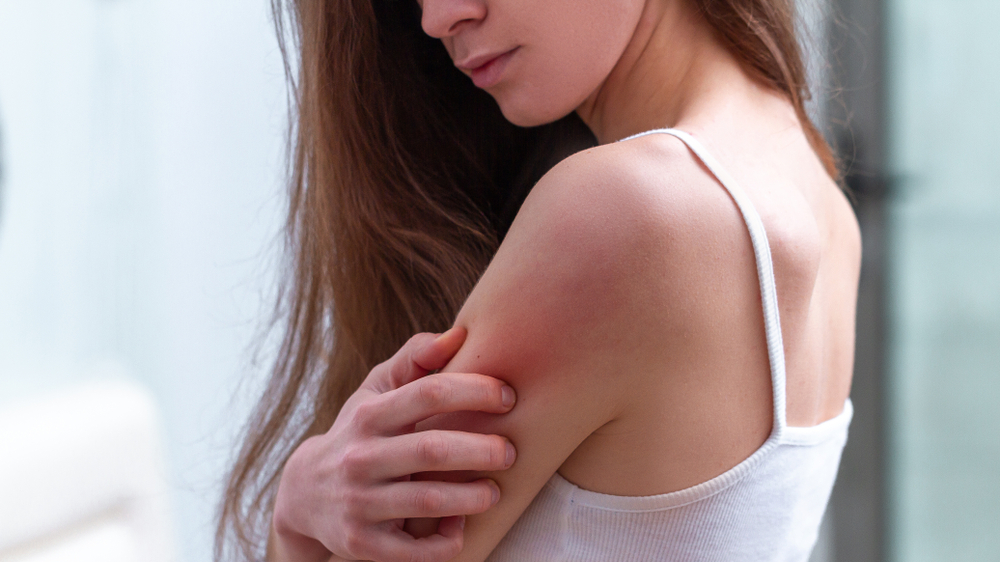 Young woman suffering from itching on her skin