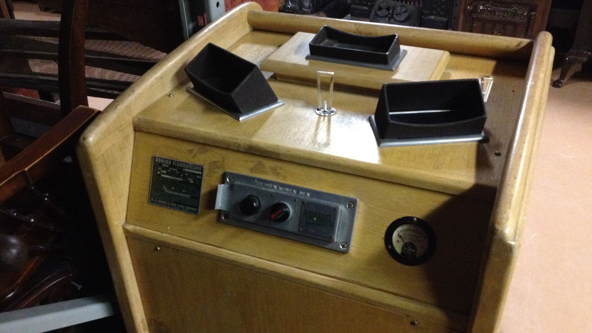 This decommissioned Adrian Fluoroscope is part of the collection of the Dufferin County Museum in Ontario, Canada. This image shows the operator's controls and three viewing screens on the top of the device. On the opposite side is a low platform with two