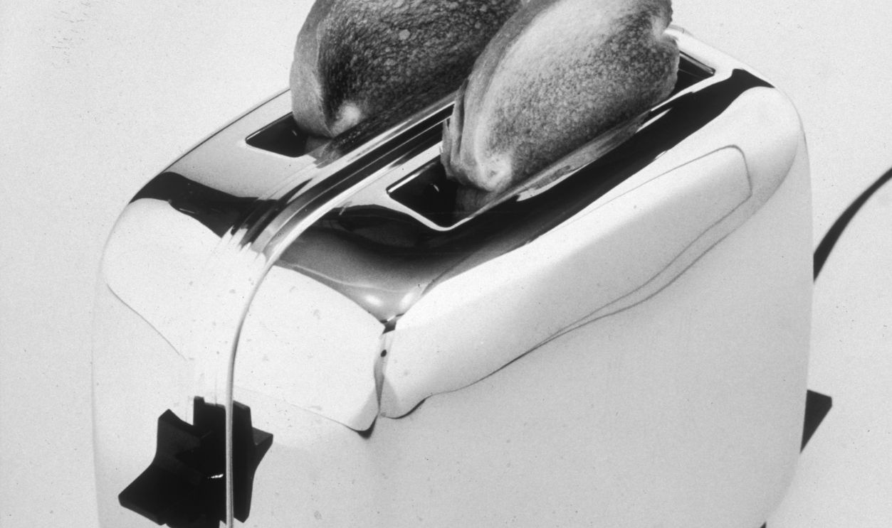 Still life of a shiny chrome Toastmaster toaster with two pieces of well-done toast sitting in its slots.