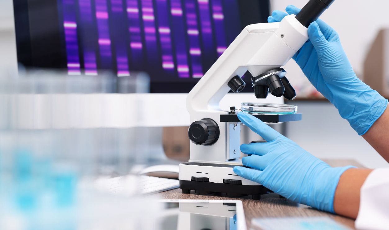 Research in genetics. Scientist working with microscope at table in laboratory, closeup
