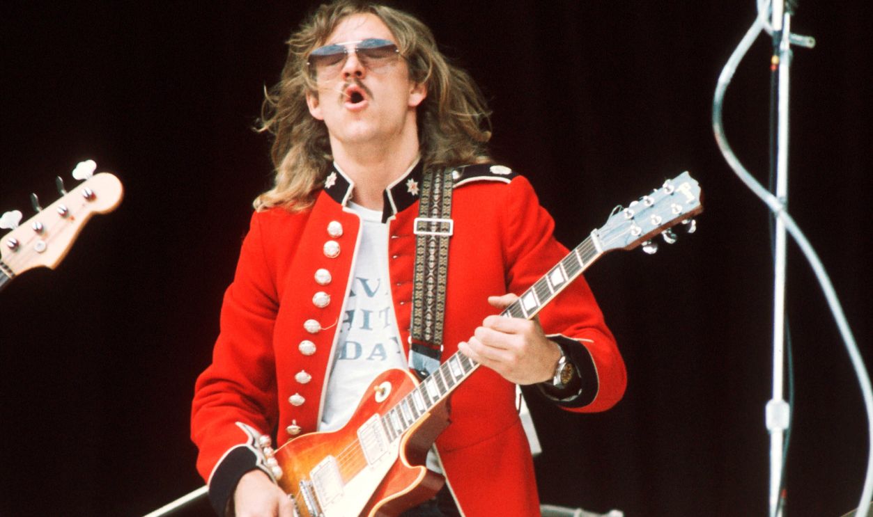Joe Walsh of The Eagles performs on stage wearing a vintage military jacket at Wembley Stadium, London, 14th September 1974.