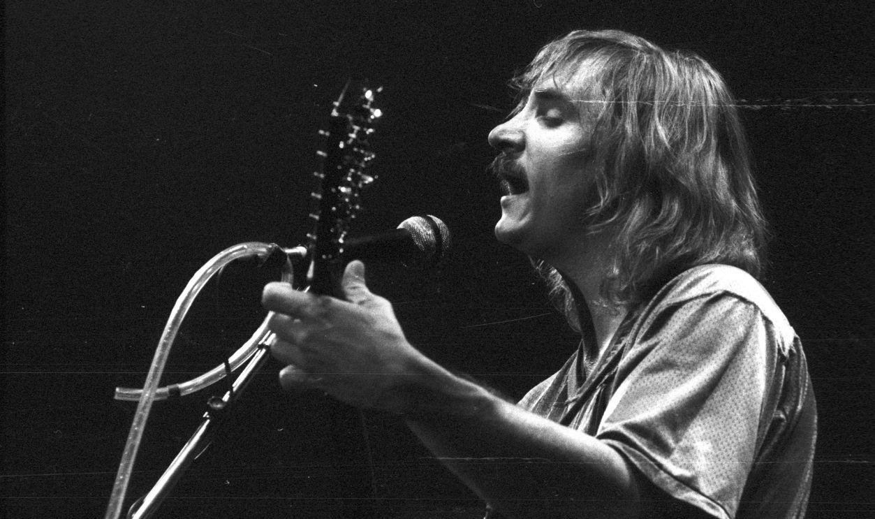Musician Joe Walsh of the rock band 'Eagles' performs onstage with an acoustic guitar at the Omni Theatre on June 20, 1977 in Atlanta, Georgia. 