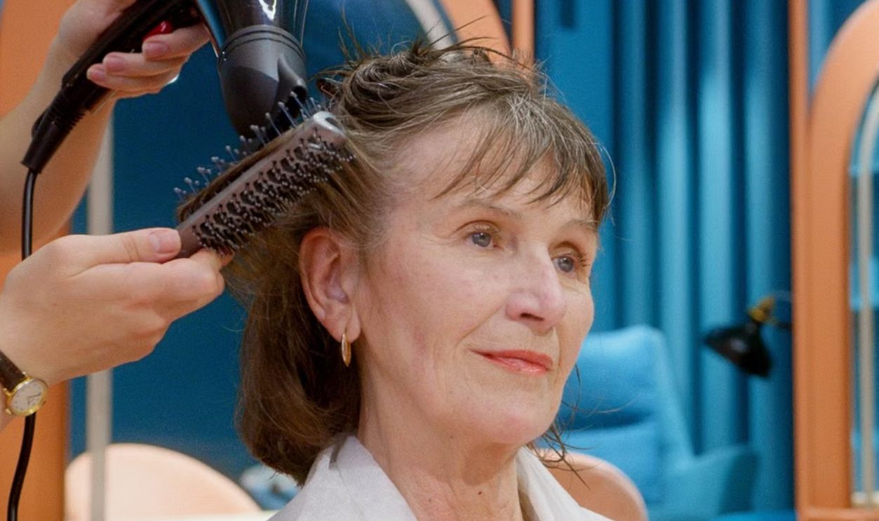 A senior woman receives hairstyling and pampering in a modern salon setting