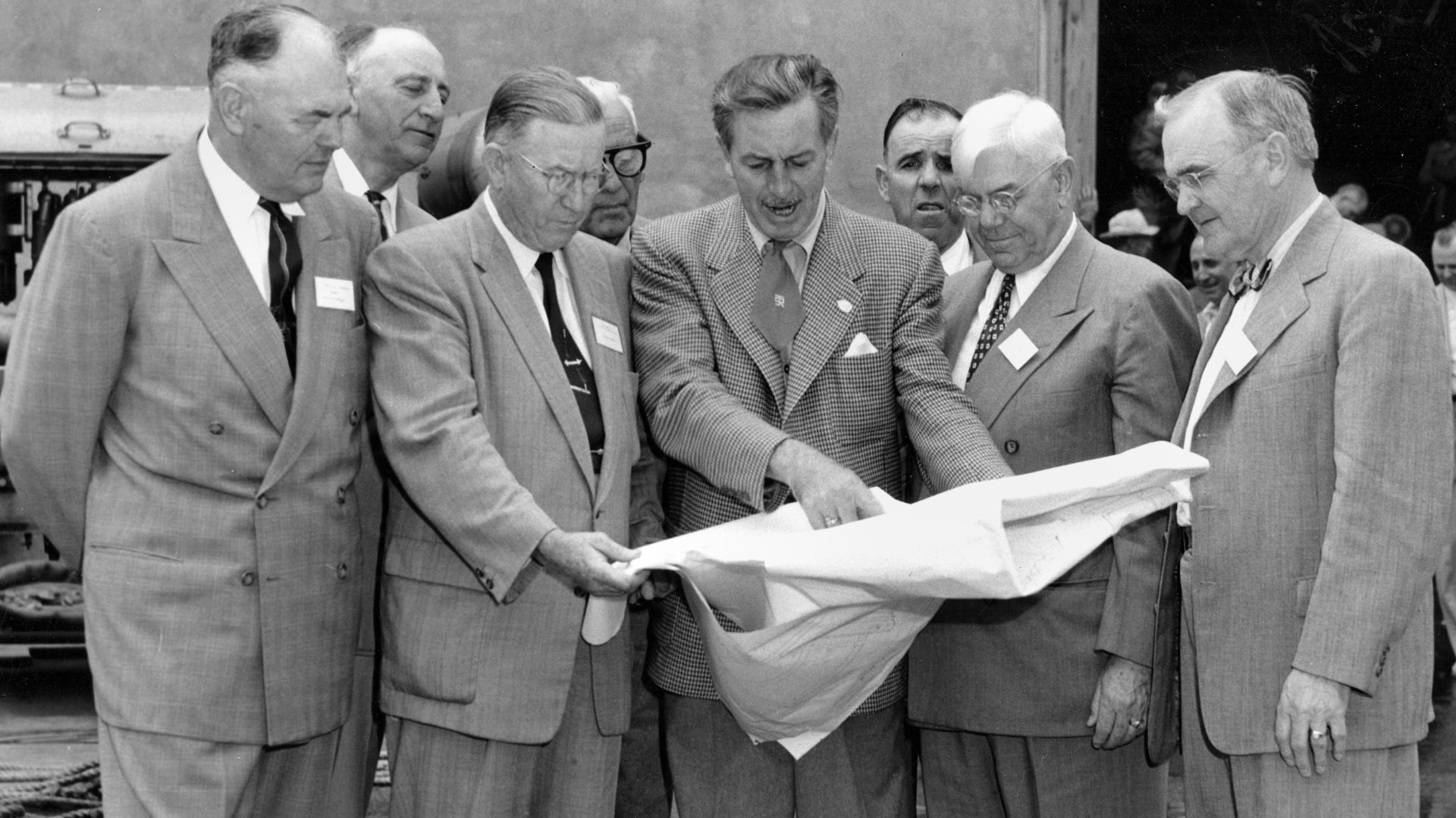Walt Disney shows Disneyland plans to Orange County officials in December 1954. The men in the front row (left to right) are Anaheim Mayor Charles Pearson, Orange County Supervisor Willis Warner, Walt Disney, Supervisor Willard Smith, and Orange County Pl