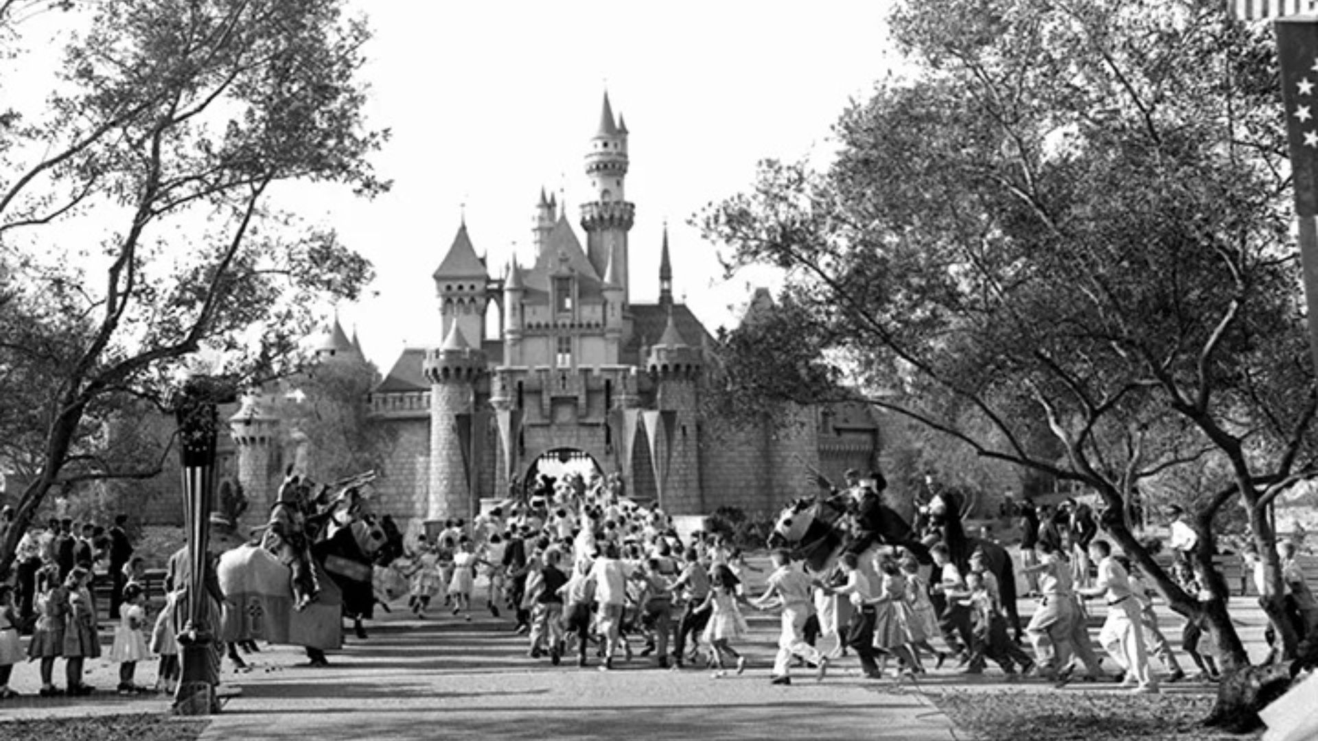 Children run across a drawbridge into the Fantasyland castle during Disneyland’s opening day in Anaheim.