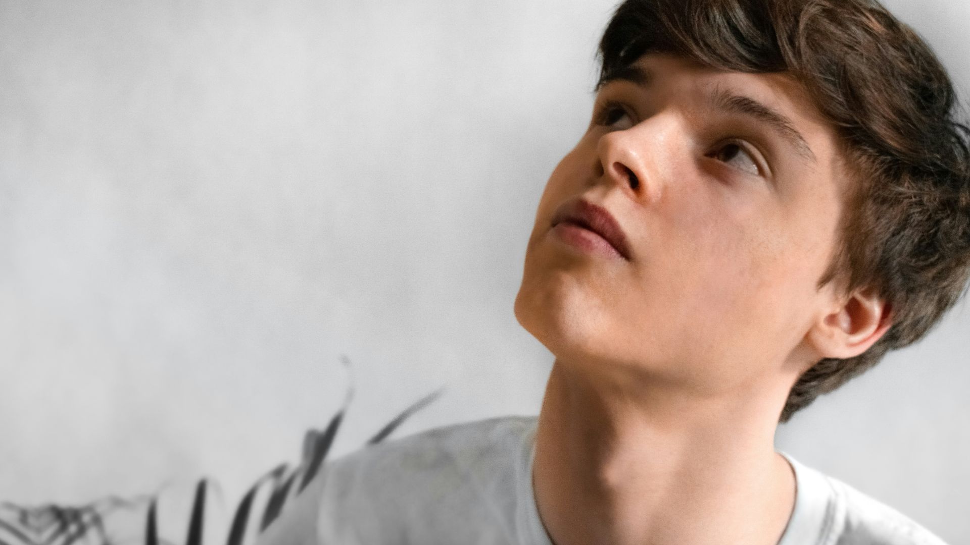 man wearing gray top looking up