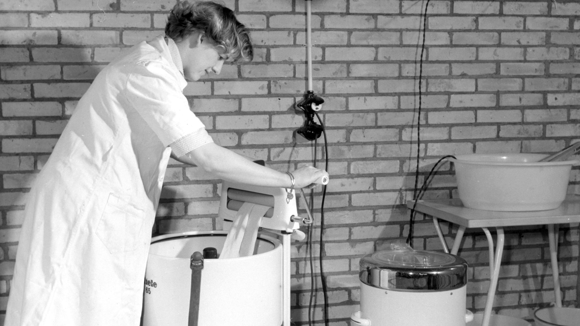 Nationaal Archief / Spaarnestad Photo, SFA001013608
Vrouw (mevrouw Bex) haalt de was door de wringer bovenop een Miele langzaamwasser. Rechts: een Miele centrifuge. Maarssen, februari 1957.
Wringer, Miele washing-machine and Miele centrifuge. The Netherla