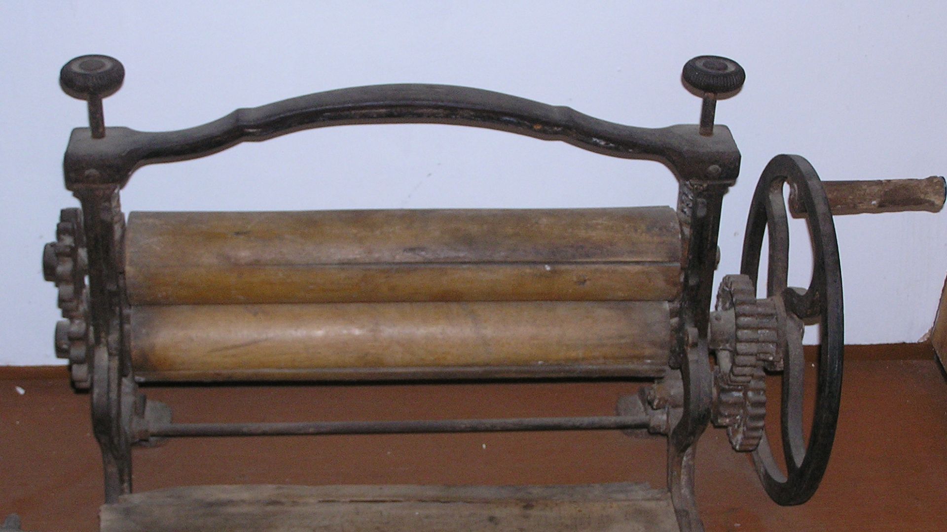 Mangle, used to wring water from wet laundry, consisting of two wooden rollers on a stand, powered by a hand crank.  History museum of Truskavets